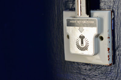 Close-up of electric lamp hanging on wall