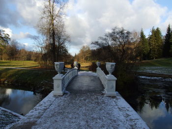 Gazebo on footpath by lake against sky