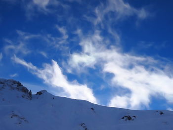 Scenic view of snow covered mountains against blue sky