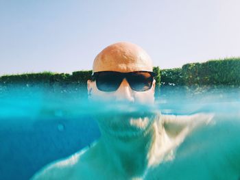 Portrait of man in swimming pool against clear sky