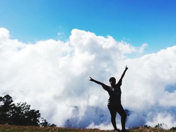 Rear view of silhouette man standing against sky