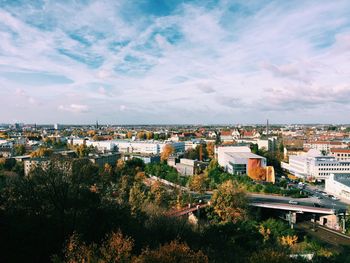 Aerial view of city against cloudy sky