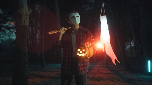 Rear view of man standing on field at night