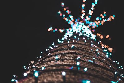 Low angle view of illuminated lights against sky at night