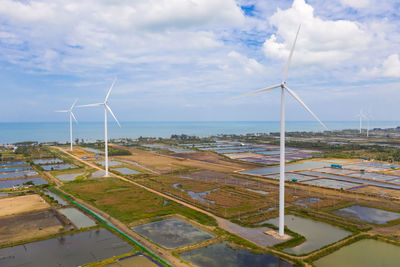 Wind turbines on land against sky