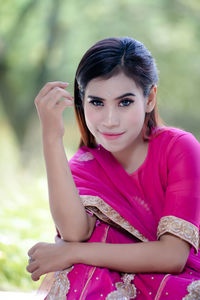 Portrait of young woman sitting on field