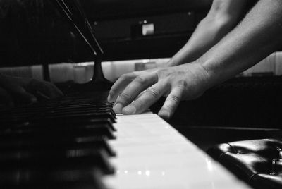 Cropped hands of man playing piano