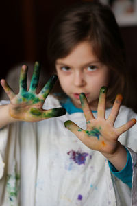 Portrait of girl showing watercolor paint on palm