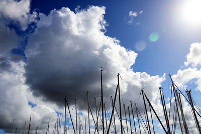 Sailboat masts against clouds - sunny day with cloudscape
