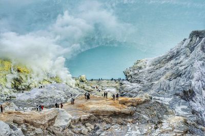 Panoramic view of people on kawah ijen volcano landscape