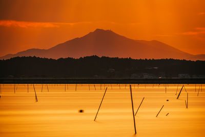 Scenic view of lake against orange sky