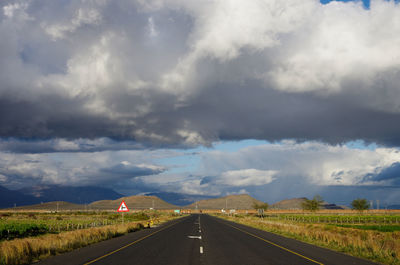 Road against storm clouds over landscape