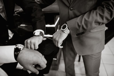 Midsection of businessmen showing wrist watches
