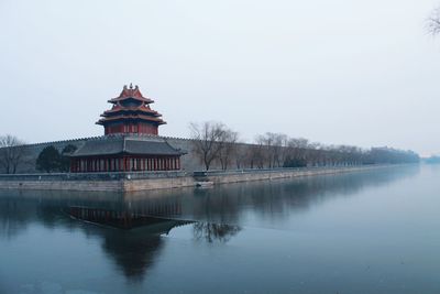 Temple by river against clear sky