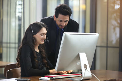 Young couple looking at camera while sitting on table