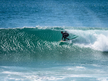 Side view of man surfing on sea waves