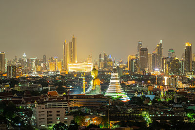 Illuminated modern buildings in city against sky