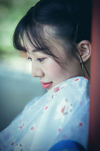 Close-up of woman looking down outdoors