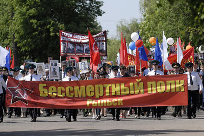 People on street against trees in city