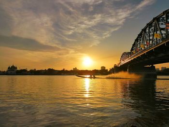 Bridge over river against sky during sunset