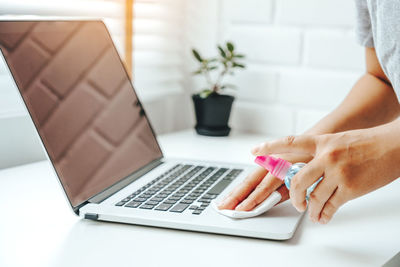 Midsection of woman using laptop on table