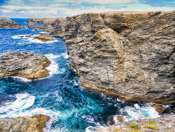 Rock formation in sea against sky