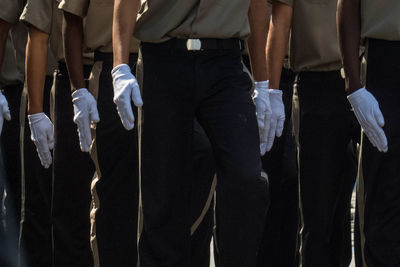 Low section of men standing on tiled floor