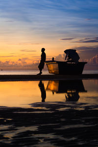 A man leaning against a boat in the morning