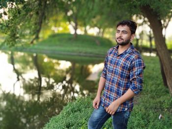 Portrait of young man standing against plants