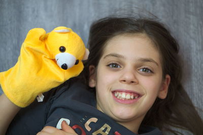 High angle portrait of girl playing with toy while lying on floor