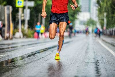 Perfect legs runner athlete man run in rainy weather marathon