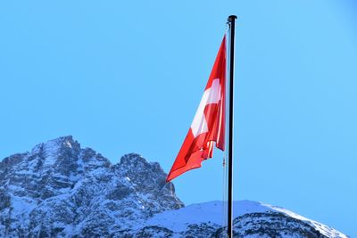 Low angle view of flag against clear blue sky