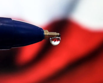 Close-up of water drops on red camera