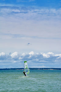 Man surfing in sea against sky