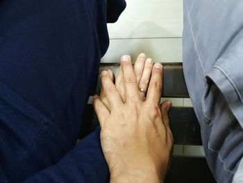 Directly above shot of couple holding hand while sitting on bench