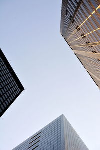 Directly below shot of modern buildings against clear sky