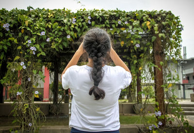 Rear view of woman standing against plants