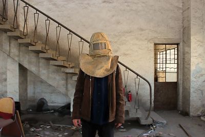 Person wearing mask while standing in abandoned building