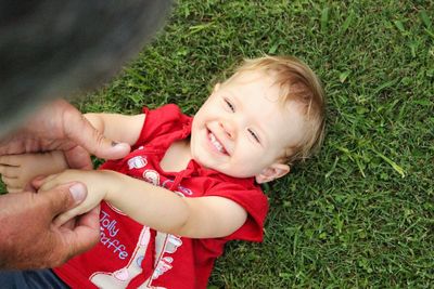 Cropped image of grandfather playing with granddaughter on field