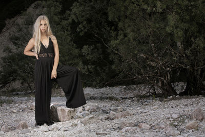 Portrait of beautiful young woman standing on stones