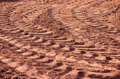 High angle view of tire tracks on sand