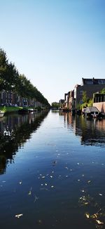Canal amidst houses against sky in city