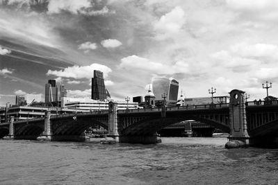 Bridge over river against cloudy sky