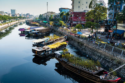 High angle view of fishing boats moored at river in city