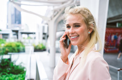 Portrait of smiling woman using mobile phone