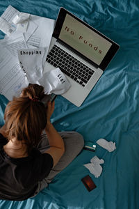 High angle view of woman using laptop on bed