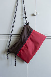 Close-up of red flags hanging against white wall