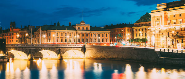 Bridge over river in city at night