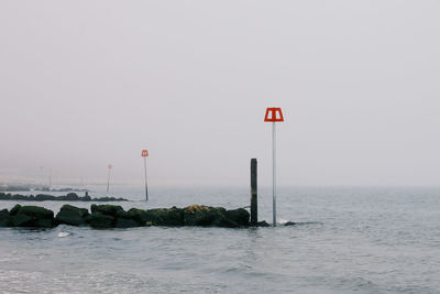 A safety pole on rocks by the sea