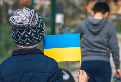 Children or kids with luggage, suitcase or bag and ukrainian flag, during war refugee, refugees camp